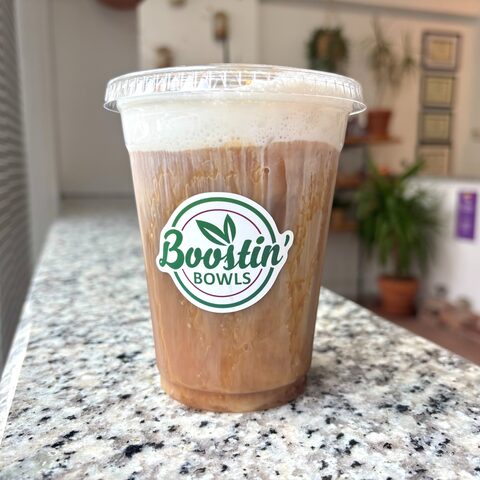 Iced caramel latte with a creamy top in a Boostin' Bowls cup