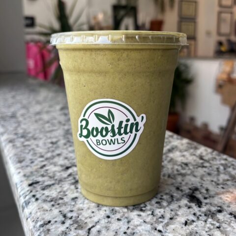 Brown smoothie with almond milk, banana, spinach, cocoa, seeds, peanut butter, and protein